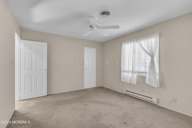 carpeted empty room featuring baseboard heating and ceiling fan