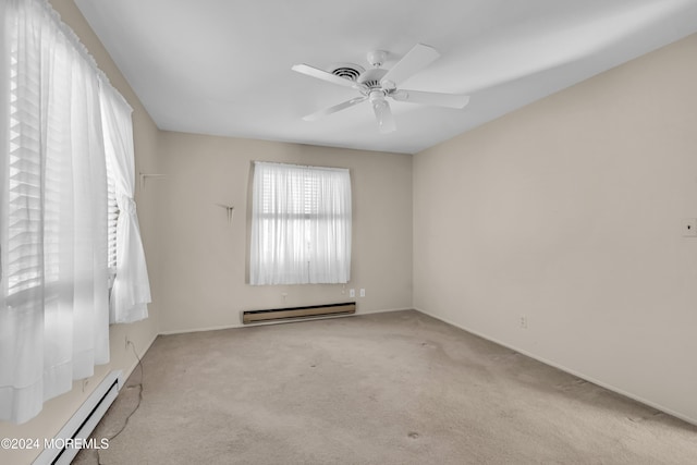 carpeted empty room featuring ceiling fan and a baseboard heating unit