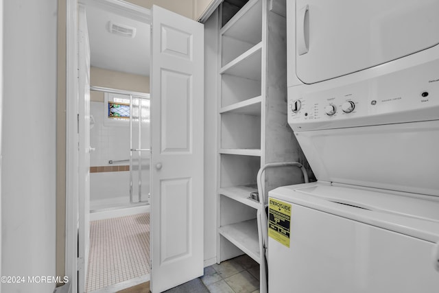 laundry room with light tile patterned flooring and stacked washer and dryer