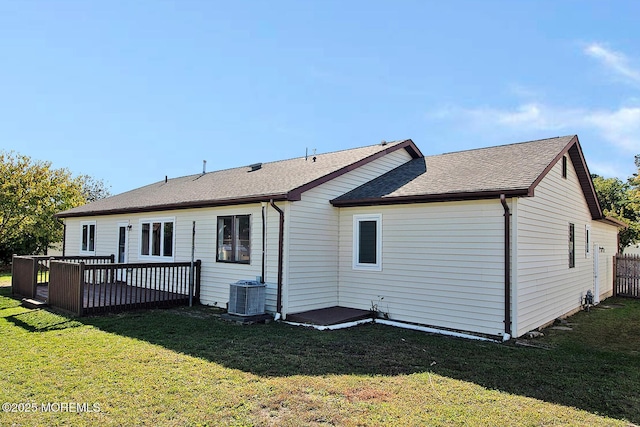 back of property featuring roof with shingles, a yard, a wooden deck, and central air condition unit