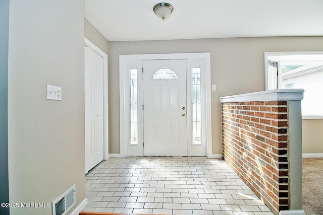 foyer entrance featuring visible vents and baseboards