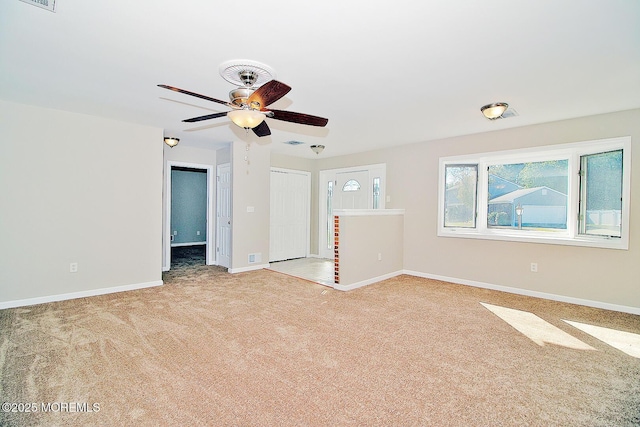 carpeted empty room featuring visible vents, ceiling fan, and baseboards