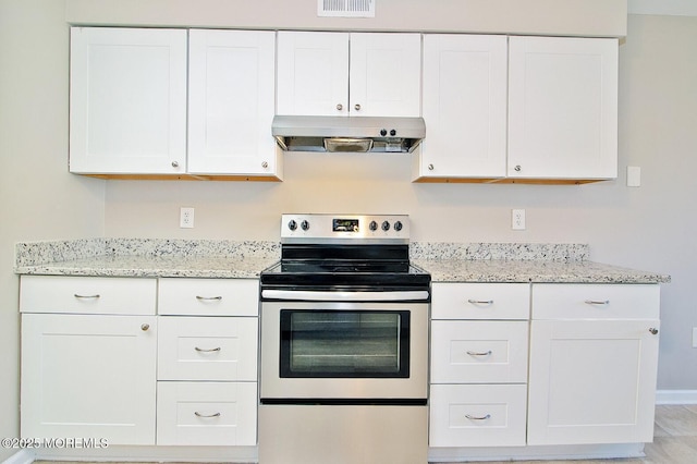 kitchen with under cabinet range hood, light stone counters, white cabinets, and electric stove