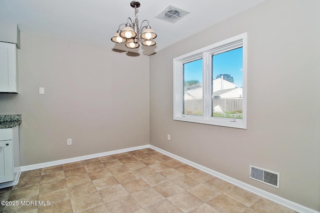 unfurnished dining area with visible vents, baseboards, and an inviting chandelier