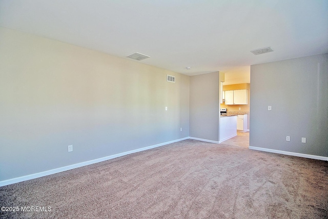 empty room with light colored carpet, visible vents, and baseboards