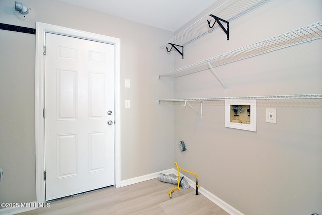 laundry area featuring laundry area, washer hookup, light wood-style flooring, and baseboards