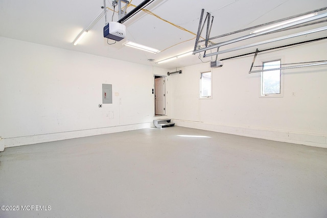 garage with baseboards, electric panel, and a garage door opener