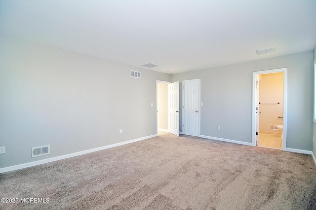 unfurnished bedroom featuring baseboards, visible vents, connected bathroom, and carpet flooring