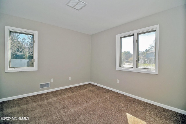 carpeted empty room with visible vents and baseboards