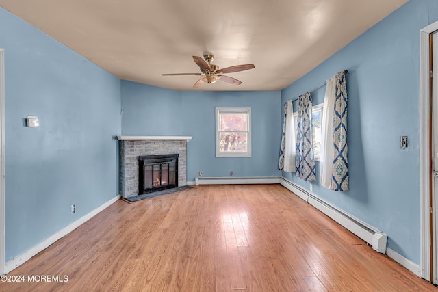 unfurnished living room featuring a brick fireplace, ceiling fan, light hardwood / wood-style floors, and a baseboard radiator