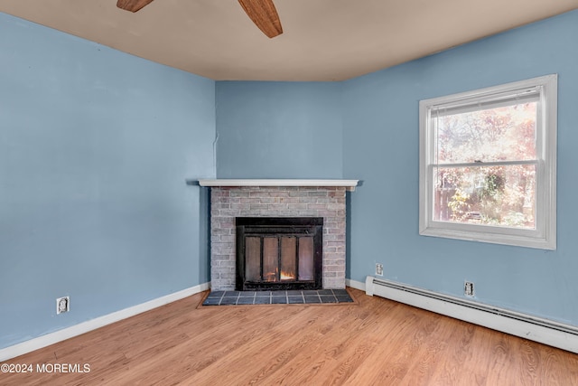 unfurnished living room featuring a fireplace, light hardwood / wood-style flooring, baseboard heating, and ceiling fan