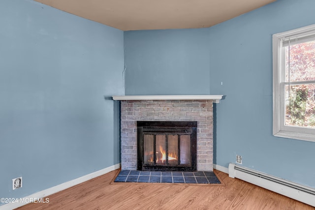 details featuring wood-type flooring, a brick fireplace, and a baseboard heating unit