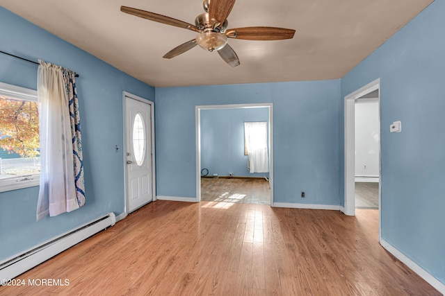 entryway featuring ceiling fan, plenty of natural light, light hardwood / wood-style floors, and a baseboard heating unit