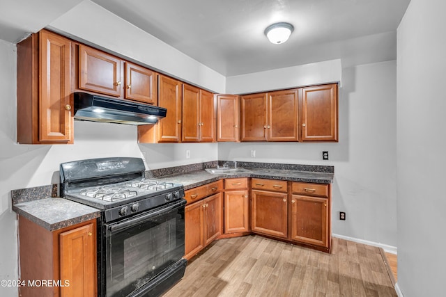 kitchen featuring black range with gas stovetop, light wood-type flooring, and sink