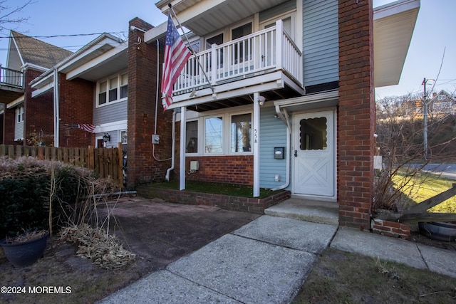 view of exterior entry with a balcony