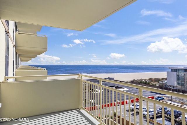 balcony featuring a water view and a view of the beach