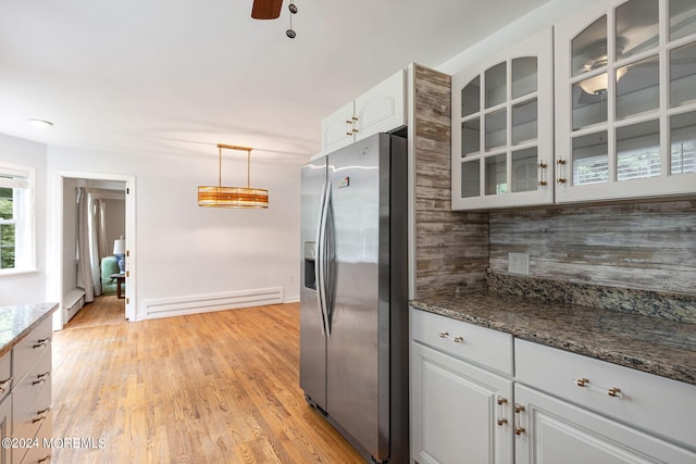 kitchen featuring baseboard heating, dark stone countertops, stainless steel fridge with ice dispenser, white cabinetry, and hanging light fixtures