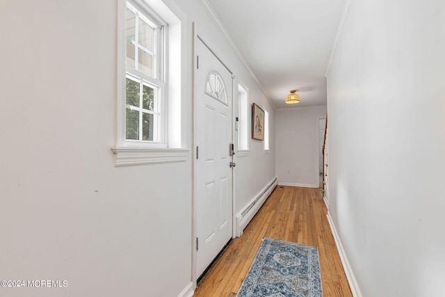 doorway to outside featuring a baseboard radiator, crown molding, and light hardwood / wood-style floors