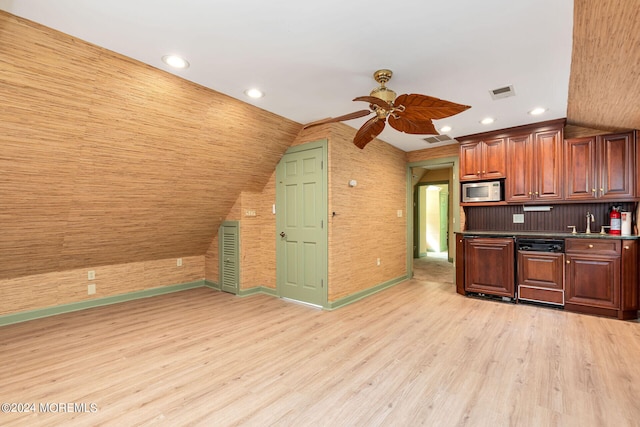 kitchen with ceiling fan, stainless steel microwave, light hardwood / wood-style floors, and vaulted ceiling