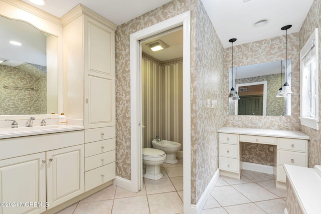 bathroom featuring tile patterned flooring, vanity, toilet, and a bidet