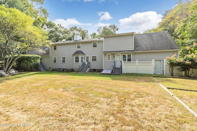 rear view of property featuring a lawn