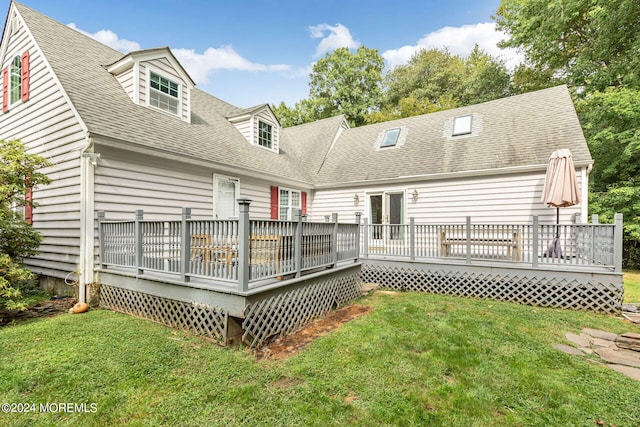 rear view of property with a lawn and a deck