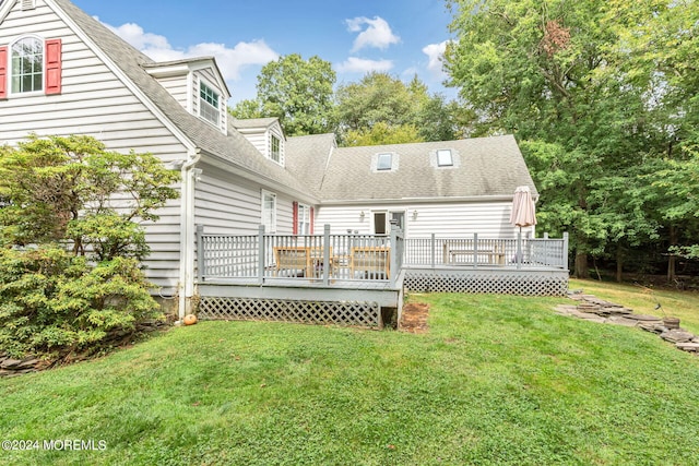 rear view of property with a yard and a deck