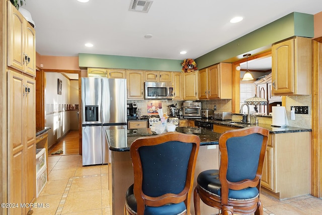 kitchen with a breakfast bar, light tile patterned floors, a center island, and stainless steel appliances