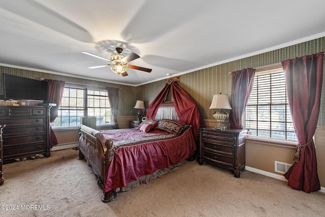 carpeted bedroom featuring baseboard heating, ceiling fan, and crown molding