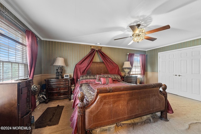 bedroom with ceiling fan, a closet, light carpet, and ornamental molding