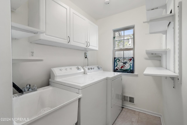 laundry area with cabinets, light tile patterned flooring, washer and clothes dryer, and sink