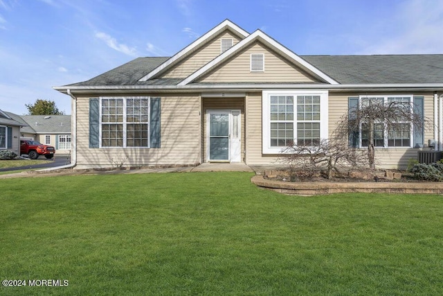 view of front of house with central AC and a front lawn
