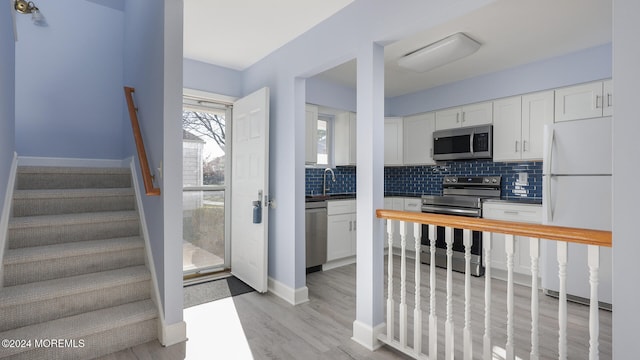 kitchen featuring white cabinetry, light wood-type flooring, and appliances with stainless steel finishes