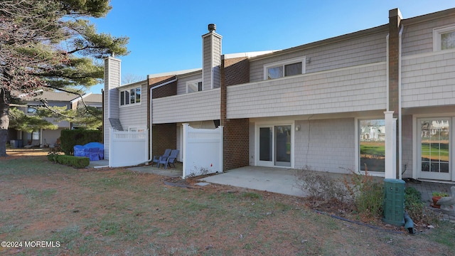 back of property with a yard and a patio