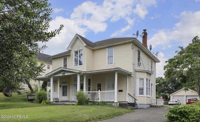 view of front of home with an outbuilding, a garage, and a front lawn