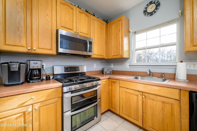 kitchen with light tile patterned floors, sink, and appliances with stainless steel finishes