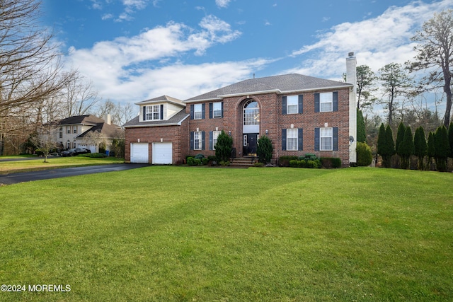 view of front of house with a garage and a front lawn