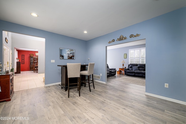 dining area with bar and hardwood / wood-style floors