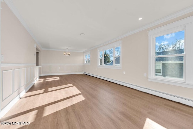 interior space featuring an inviting chandelier, a baseboard heating unit, crown molding, and light hardwood / wood-style flooring