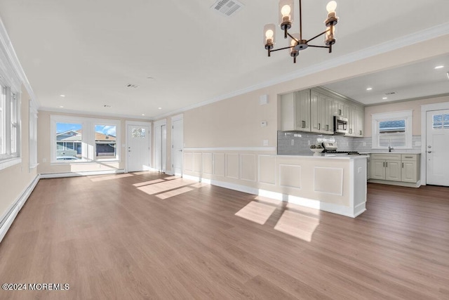 unfurnished living room with ornamental molding, a chandelier, and light hardwood / wood-style floors