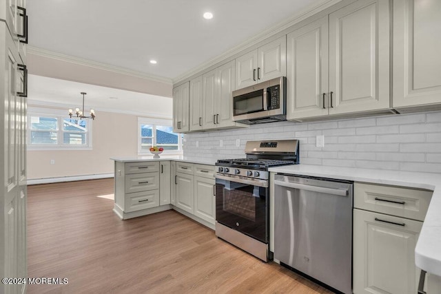 kitchen featuring white cabinetry, an inviting chandelier, stainless steel appliances, ornamental molding, and light hardwood / wood-style floors