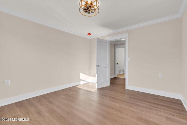 empty room featuring ornamental molding and light wood-type flooring