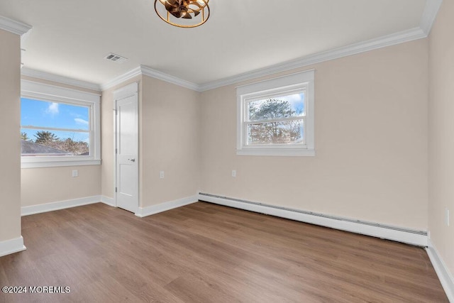 unfurnished room featuring baseboard heating, ornamental molding, and a wealth of natural light