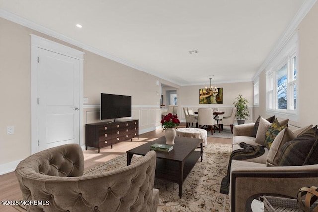 living room featuring crown molding, light hardwood / wood-style floors, and a chandelier