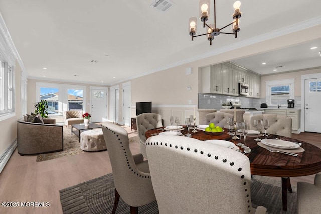 dining room with crown molding, hardwood / wood-style floors, and a chandelier