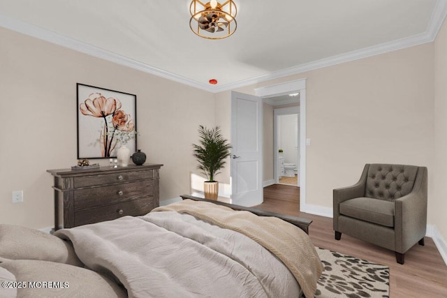 bedroom featuring ornamental molding, a notable chandelier, and light hardwood / wood-style flooring