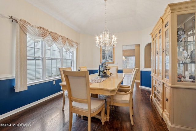 dining area featuring dark wood-type flooring and a notable chandelier