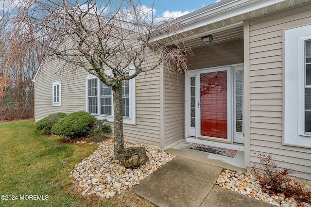 doorway to property featuring a lawn