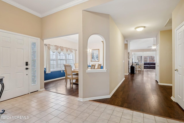 entrance foyer with ceiling fan, light hardwood / wood-style flooring, a healthy amount of sunlight, and ornamental molding