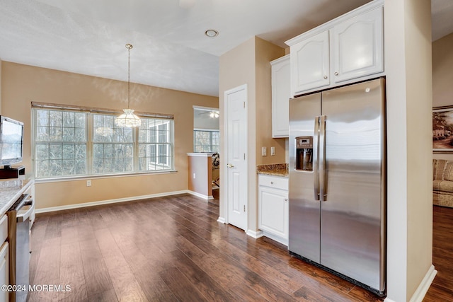 kitchen featuring light stone countertops, white cabinets, hanging light fixtures, and stainless steel refrigerator with ice dispenser